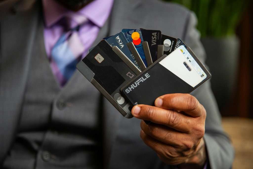 Man holding multiple credit cards representing credit card debt refinancing and balance transfer options.